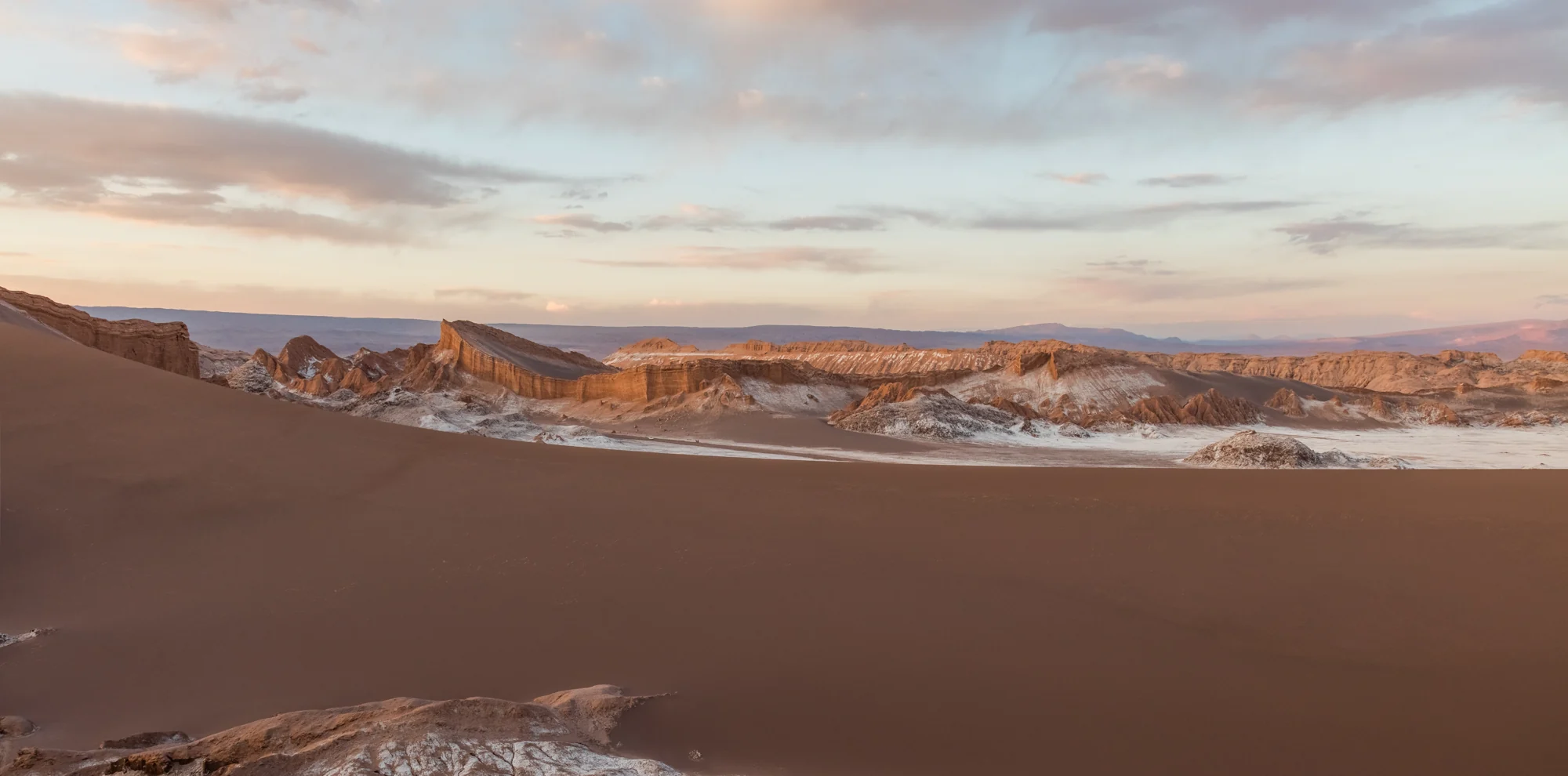 Dunas y formaciones rojizas del Valle de la Luna al atardecer